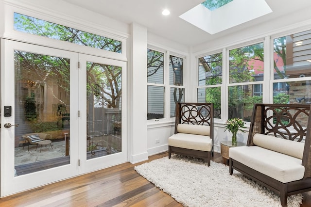 sunroom / solarium featuring a skylight, wood finished floors, and recessed lighting