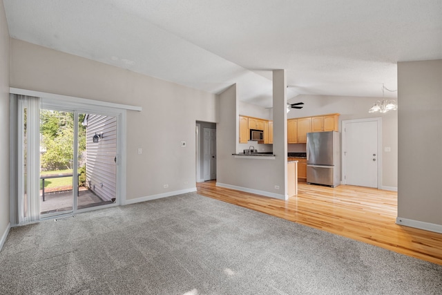 400 Bayview Ave, Naperville, IL 60565 - unfurnished living room with light carpet, vaulted ceiling, baseboards, a chandelier, and ceiling fan