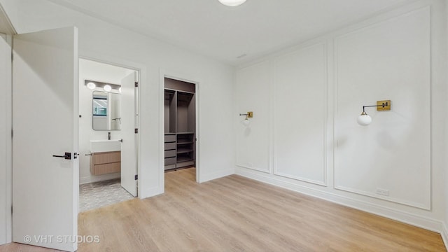 642 W Webster Ave Unit 1, Chicago, IL 60614 - unfurnished bedroom with light wood-style flooring, a spacious closet, a decorative wall, ensuite bathroom, and a closet
