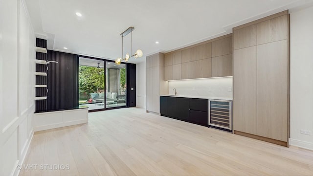 642 W Webster Ave Unit 1, Chicago, IL 60614 - unfurnished living room with beverage cooler, bar with sink, light wood-style floors, a wall of windows, and recessed lighting