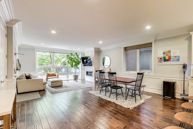 2312 W Belmont Ave Unit 1W, Chicago, IL 60618 - dining space with ornamental molding, dark wood finished floors, a fireplace, a decorative wall, and recessed lighting