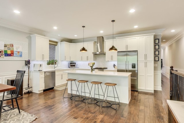 2312 W Belmont Ave Unit 1W, Chicago, IL 60618 - kitchen featuring stainless steel appliances, wall chimney exhaust hood, ornamental molding, white cabinets, and a breakfast bar