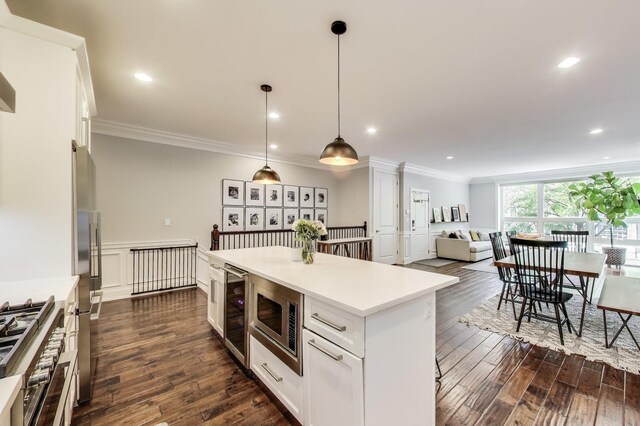 2312 W Belmont Ave Unit 1W, Chicago, IL 60618 - kitchen featuring stainless steel appliances, ornamental molding, white cabinetry, dark wood-style floors, and recessed lighting