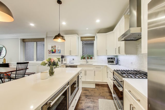 2312 W Belmont Ave Unit 1W, Chicago, IL 60618 - kitchen with appliances with stainless steel finishes, wall chimney exhaust hood, dark wood-type flooring, ornamental molding, and light countertops