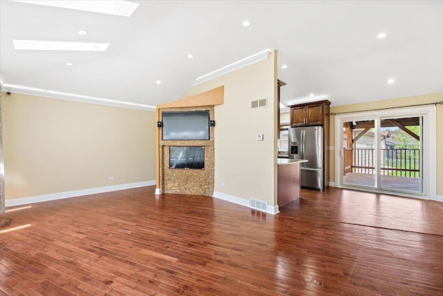 703 Berkshire Ln, Schaumburg, IL 60193 - unfurnished living room with lofted ceiling, a skylight, a glass covered fireplace, crown molding, and dark wood-style flooring