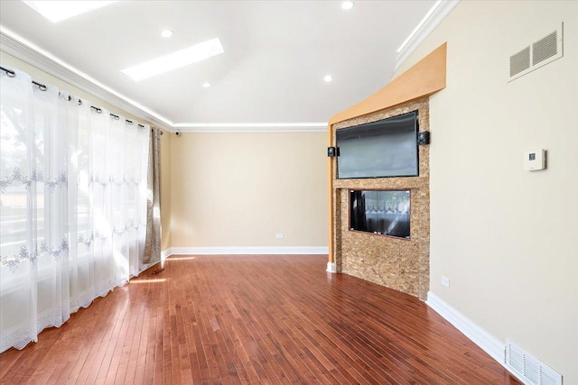 703 Berkshire Ln, Schaumburg, IL 60193 - unfurnished living room with a glass covered fireplace, crown molding, hardwood / wood-style floors, baseboards, and a skylight