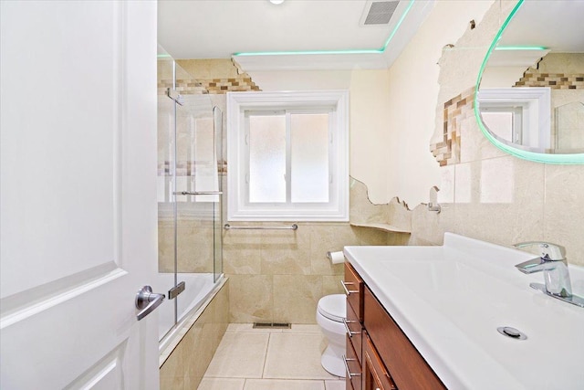 703 Berkshire Ln, Schaumburg, IL 60193 - bathroom with tile walls, toilet, tiled shower / bath, vanity, and tile patterned floors