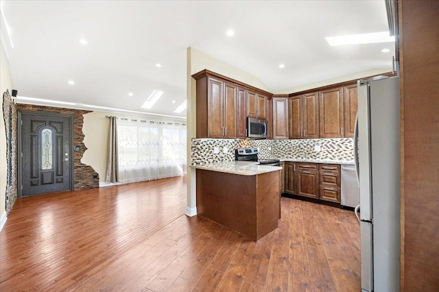 703 Berkshire Ln, Schaumburg, IL 60193 - kitchen with appliances with stainless steel finishes, tasteful backsplash, wood finished floors, light stone countertops, and a peninsula