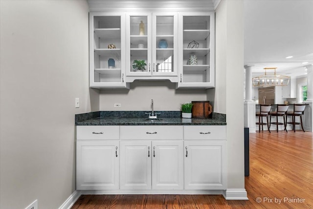 3 Woodley Mnr, Winnetka, IL 60093 - bar with stainless steel built in refrigerator, a sink, wood finished floors, ornate columns, and a chandelier
