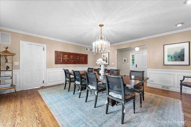 3 Woodley Mnr, Winnetka, IL 60093 - dining space featuring wood finished floors, a chandelier, ornamental molding, wainscoting, and a decorative wall