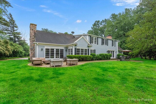 3 Woodley Mnr, Winnetka, IL 60093 - back of property featuring a chimney, an outdoor living space, a patio, and a lawn