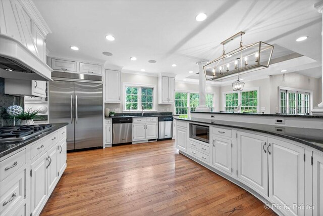3 Woodley Mnr, Winnetka, IL 60093 - kitchen with built in appliances, dark countertops, white cabinetry, light wood-style flooring, and ornamental molding