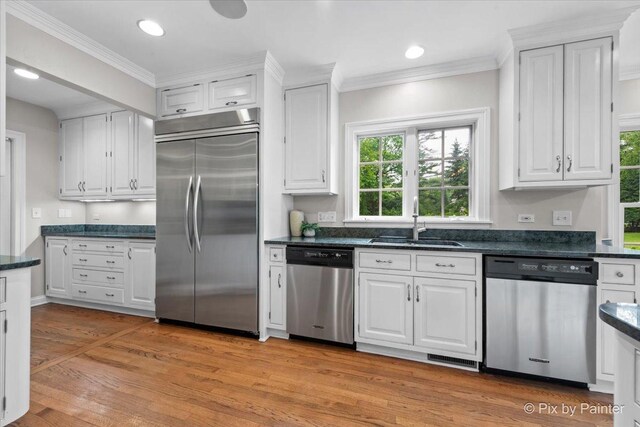 3 Woodley Mnr, Winnetka, IL 60093 - kitchen featuring stainless steel appliances, a sink, dark countertops, white cabinetry, and crown molding