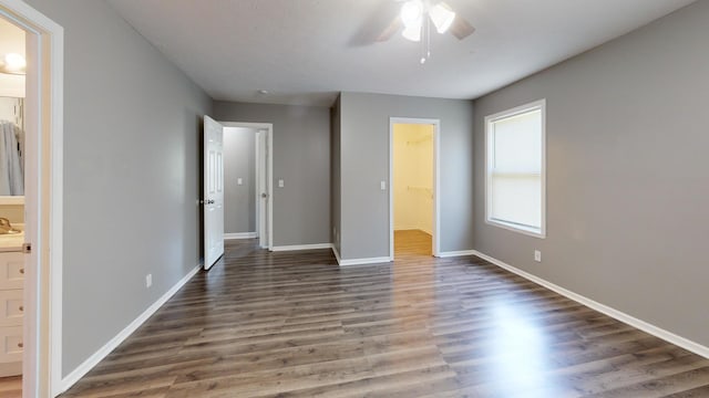 120 Harvest Glenn Dr, Davis Junction, IL 61020 - unfurnished bedroom featuring wood finished floors, a walk in closet, connected bathroom, and a ceiling fan