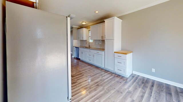120 Harvest Glenn Dr, Davis Junction, IL 61020 - kitchen featuring freestanding refrigerator, crown molding, backsplash, light wood-style flooring, and white cabinets