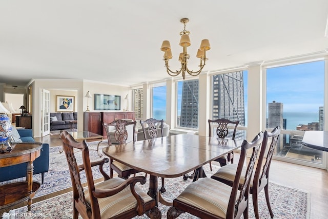 111 E Chestnut St Unit 39C, Chicago, IL 60611 - dining area featuring a chandelier, wood finished floors, crown molding, and a wall of windows