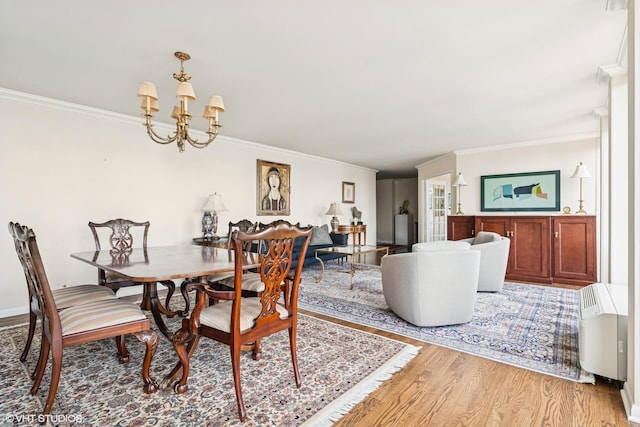 111 E Chestnut St Unit 39C, Chicago, IL 60611 - dining space with crown molding, light wood finished floors, and a chandelier