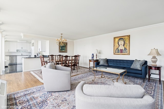 111 E Chestnut St Unit 39C, Chicago, IL 60611 - living room featuring a chandelier, ornamental molding, light wood-style flooring, and baseboards