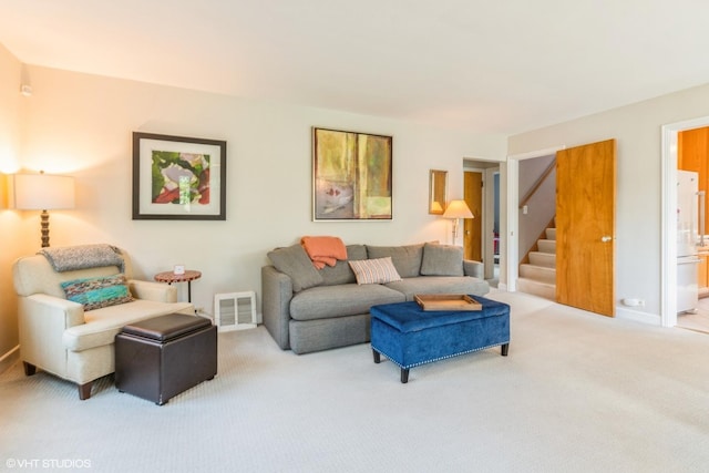 carpeted living room featuring stairway and baseboards