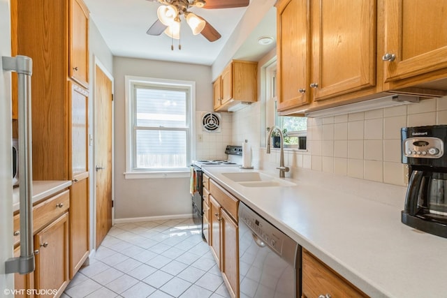 kitchen with stainless steel dishwasher, range with electric cooktop, a sink, backsplash, and baseboards