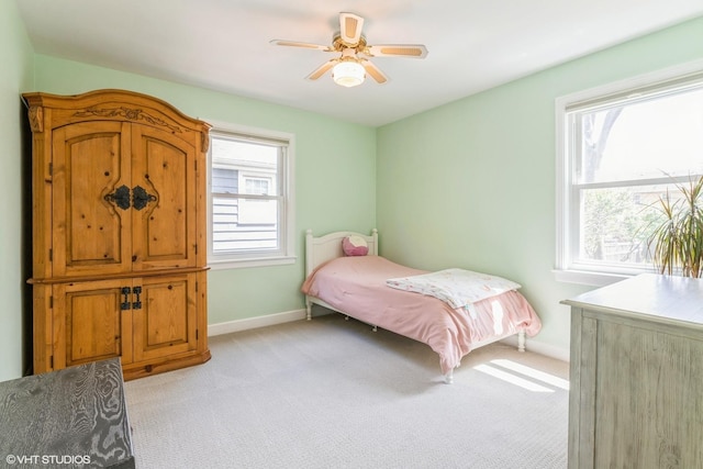 bedroom with light colored carpet, multiple windows, and baseboards