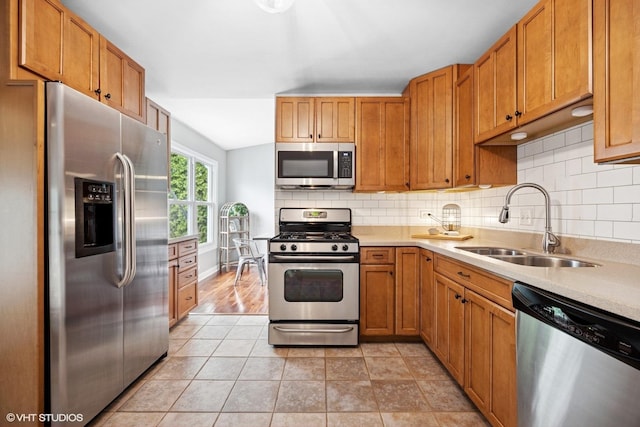 269 Cascade Dr, Crystal Lake, IL 60012 - kitchen featuring stainless steel appliances, a sink, light countertops, backsplash, and brown cabinetry