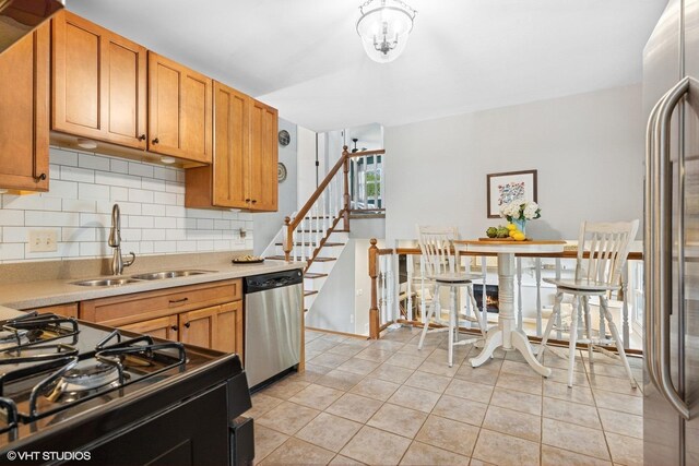 269 Cascade Dr, Crystal Lake, IL 60012 - kitchen with appliances with stainless steel finishes, a sink, backsplash, light countertops, and light tile patterned flooring