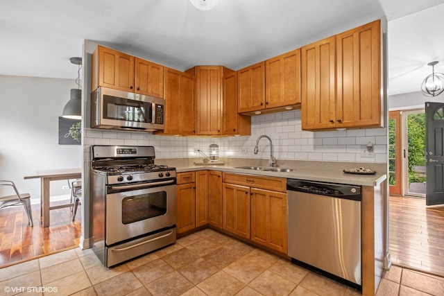 269 Cascade Dr, Crystal Lake, IL 60012 - kitchen featuring stainless steel appliances, a sink, light countertops, backsplash, and brown cabinets