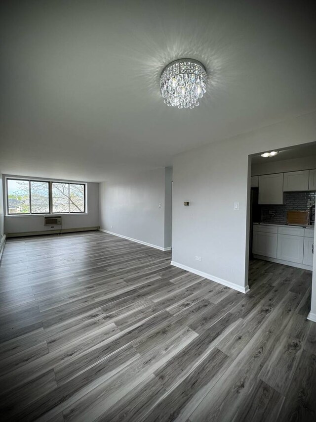 9720 S Pulaski Rd Unit 306, Oak Lawn, IL 60453 - unfurnished living room featuring a chandelier, wood finished floors, and baseboards