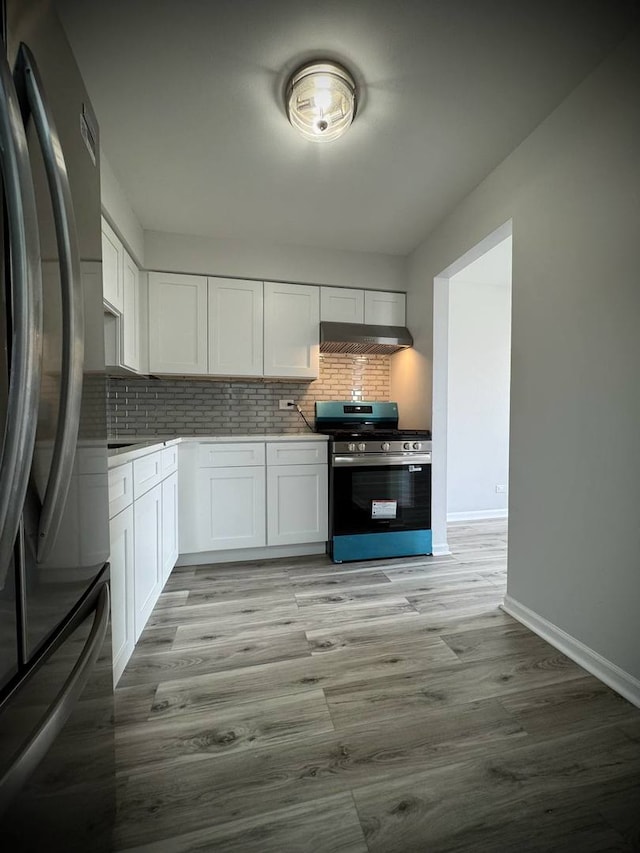 9720 S Pulaski Rd Unit 306, Oak Lawn, IL 60453 - kitchen with freestanding refrigerator, stainless steel range with gas cooktop, decorative backsplash, baseboards, and white cabinets