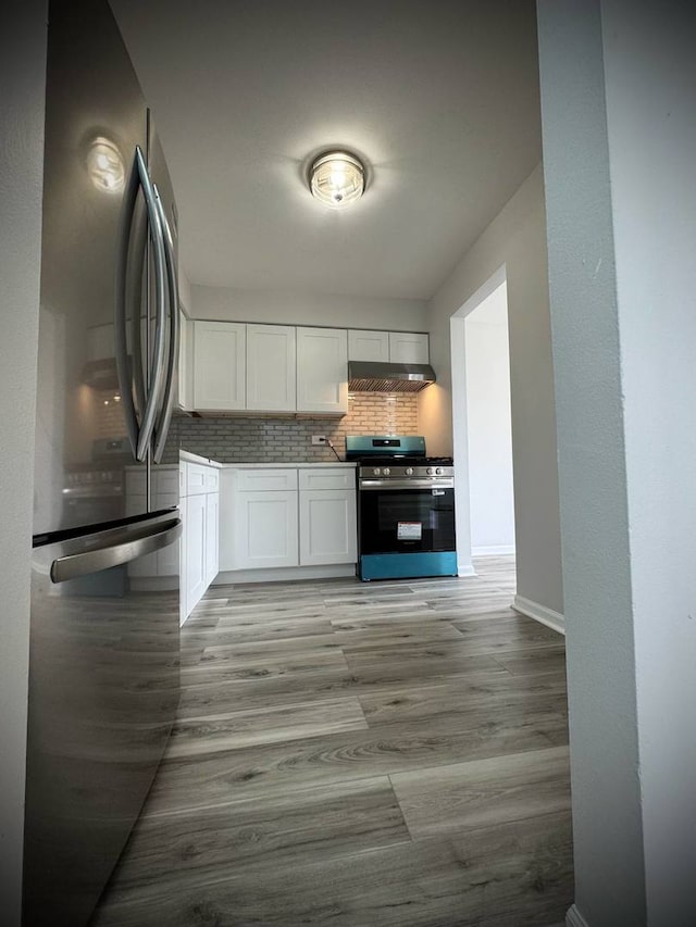 9720 S Pulaski Rd Unit 306, Oak Lawn, IL 60453 - kitchen with stainless steel appliances, under cabinet range hood, white cabinets, tasteful backsplash, and light wood-style floors
