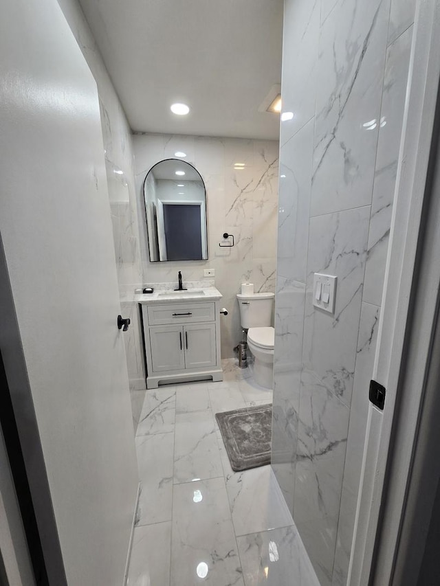 460 74th St Unit 102, Downers Grove, IL 60516 - bathroom with marble tiled floors, toilet, vanity, and recessed lighting