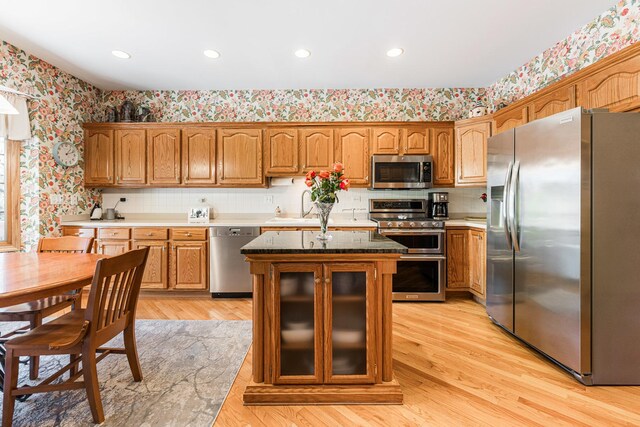1607 Park Point, Ridge Point, Park Ridge, IL 60068 - kitchen with appliances with stainless steel finishes, wallpapered walls, a sink, glass insert cabinets, and brown cabinets