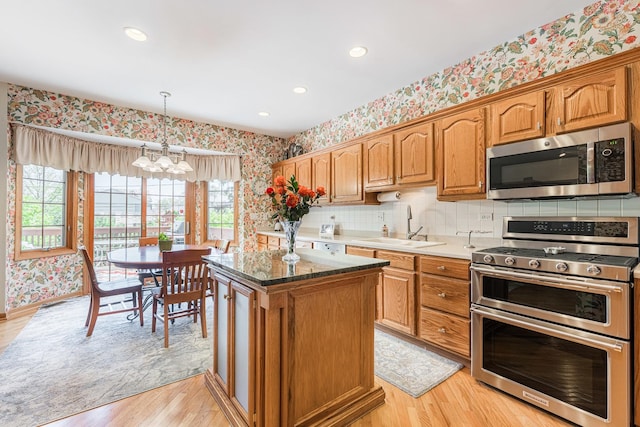 1607 Park Point, Ridge Point, Park Ridge, IL 60068 - kitchen featuring appliances with stainless steel finishes, wallpapered walls, a chandelier, a sink, and light wood-style floors