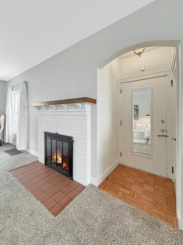 1351 W Stover St, Freeport, IL 61032 - unfurnished living room with arched walkways, a brick fireplace, and baseboards