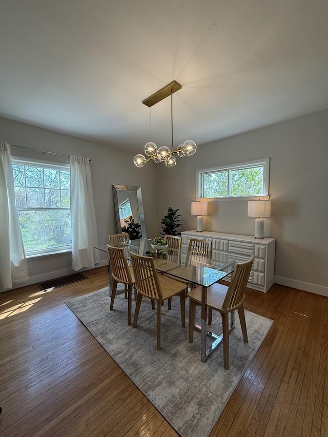 1351 W Stover St, Freeport, IL 61032 - dining area featuring wood finished floors, baseboards, and a chandelier