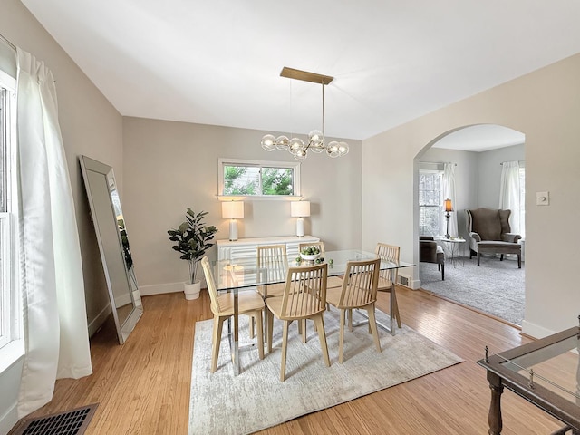 1351 W Stover St, Freeport, IL 61032 - dining room with arched walkways, light wood-style flooring, baseboards, and a chandelier
