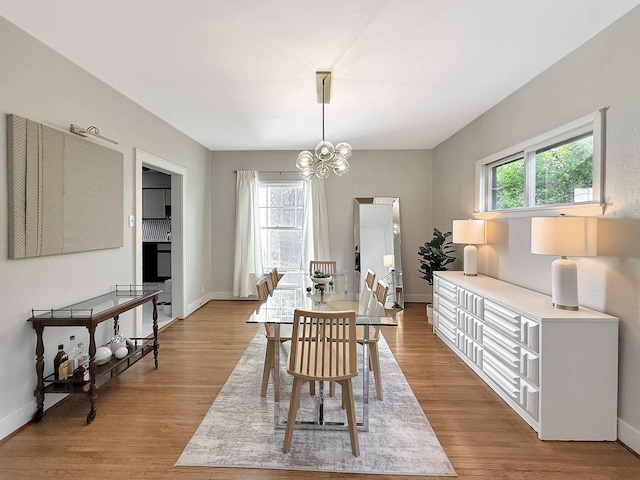 1351 W Stover St, Freeport, IL 61032 - dining room featuring a chandelier, light wood-style floors, and baseboards