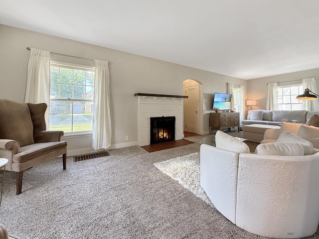 1351 W Stover St, Freeport, IL 61032 - living area with carpet flooring, a fireplace, arched walkways, and baseboards