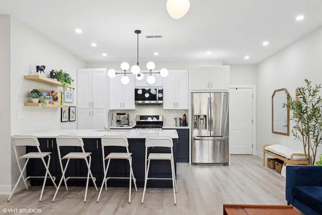 4150 N Kenmore Ave Unit 206, Chicago, IL 60613 - kitchen featuring appliances with stainless steel finishes, light countertops, a kitchen breakfast bar, a sink, and recessed lighting