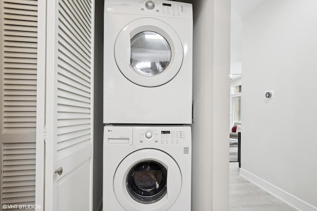 4150 N Kenmore Ave Unit 206, Chicago, IL 60613 - laundry area with stacked washing machine and dryer, baseboards, and light wood-style floors