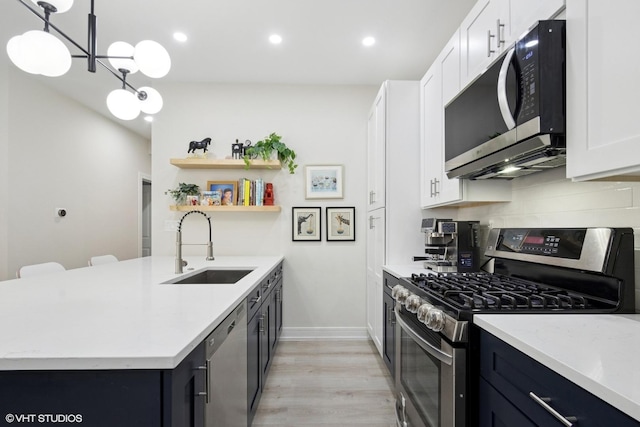 4150 N Kenmore Ave Unit 206, Chicago, IL 60613 - kitchen with appliances with stainless steel finishes, a sink, light wood-style flooring, white cabinets, and decorative backsplash