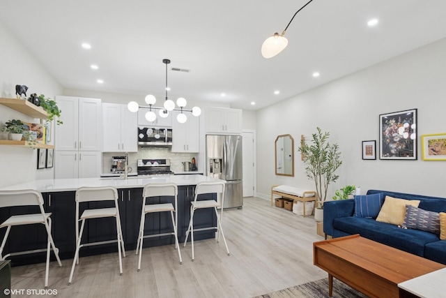 4150 N Kenmore Ave Unit 206, Chicago, IL 60613 - kitchen with appliances with stainless steel finishes, light countertops, open shelves, decorative backsplash, and a breakfast bar area
