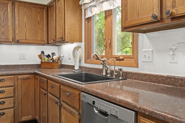 175 N Dogwood St, Cortland, IL 60112 - kitchen featuring stainless steel dishwasher, a sink, brown cabinets, and dark countertops