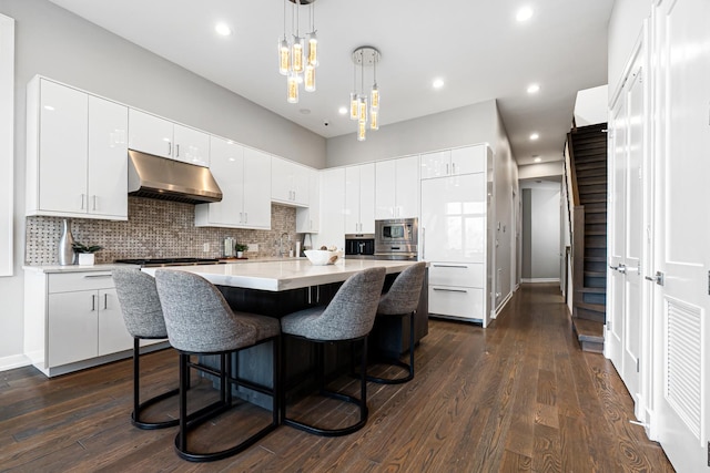 1513 W Walton St Unit 3, Chicago, IL 60642 - kitchen featuring under cabinet range hood, stainless steel appliances, white cabinetry, backsplash, and recessed lighting