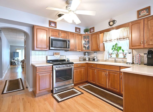 7513 W Isham Ave, Chicago, IL 60631 - kitchen with stainless steel appliances, arched walkways, light countertops, and brown cabinetry