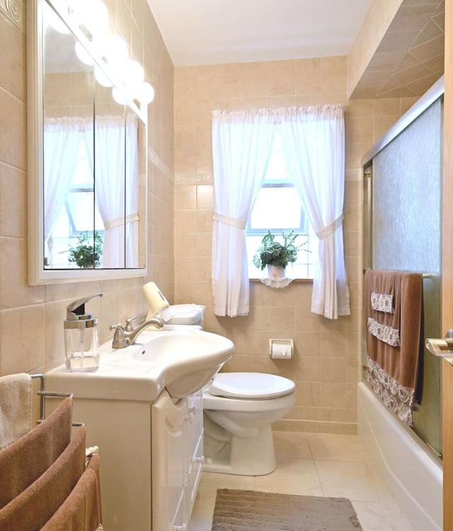 7513 W Isham Ave, Chicago, IL 60631 - bathroom featuring tile walls, vanity, plenty of natural light, toilet, and combined bath / shower with glass door