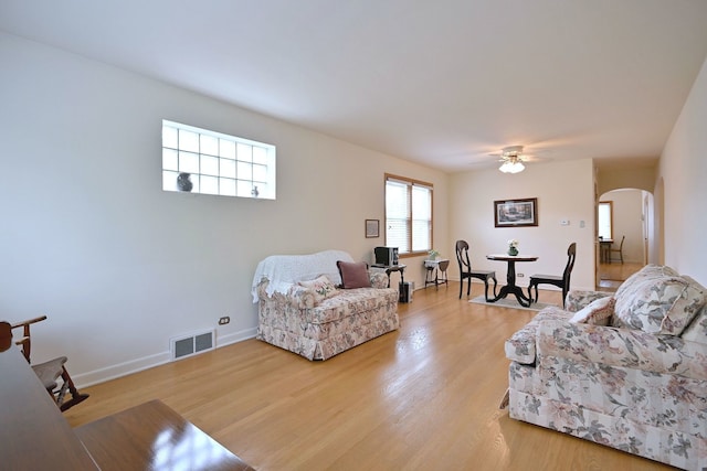 7513 W Isham Ave, Chicago, IL 60631 - living room featuring arched walkways, a ceiling fan, light wood finished floors, and baseboards