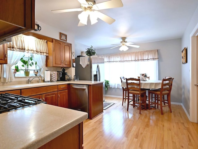 7513 W Isham Ave, Chicago, IL 60631 - kitchen with stainless steel appliances, brown cabinets, a ceiling fan, light wood finished floors, and a sink