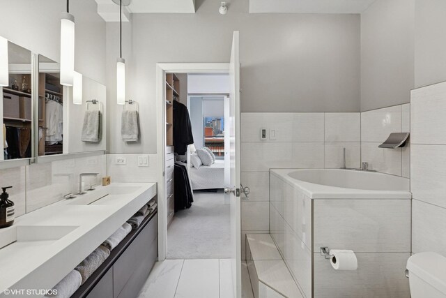 1200 W Monroe St Unit 808, Chicago, IL 60607 - ensuite bathroom with a bath, a walk in closet, double vanity, tile walls, and toilet